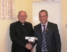 Club Chairman Brian O'Neill presents Canon Murphy with a commemorative GAA 125 plaque for his contributions  