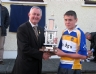 Christy Cooney presents Rasharkin captain Conor Mc Keever with the Pat Hendry Memorial Trophy 